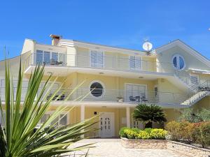 Großes gelbes Haus mit Balkon in der Unterkunft Villa Maestral Zadar in Zadar