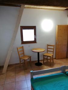 Habitación con 2 sillas, mesa y ventana en Agri Scinghiöra, en Brontallo