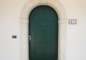 a green door in a building with an arch at Villa Green - Irpinia in Venticano