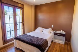 a small bedroom with a bed and a window at Complejo Hotelero La Braña in San Isidro
