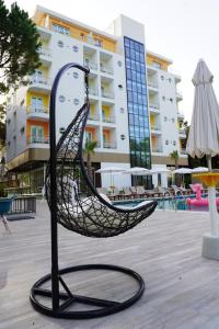una escultura de hamaca frente a un edificio en Hotel Monaco & Garden, en Golem