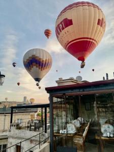 ギョレメにあるAren Cave Hotel And Art Galleryの空を飛ぶ熱気球群