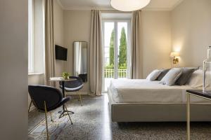 a bedroom with a bed and a table and chairs at Villa La Tuia B&B in Lucca
