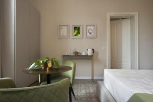 a hotel room with a bed and a table and chairs at Villa La Tuia B&B in Lucca