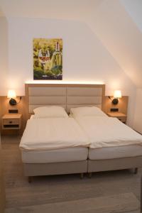a bedroom with two beds and a painting on the wall at Hotel Kallstadter Hof in Kallstadt