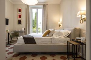 a bedroom with a bed and a desk and a window at Villa La Tuia B&B in Lucca +36 photos