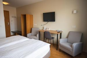 una camera d'albergo con un letto, una scrivania e una TV di Hótel Búrfell a Vík