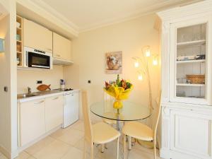 una cucina con tavolo e fiori in vaso di Apartment Cristal Croisette-1 by Interhome a Cannes