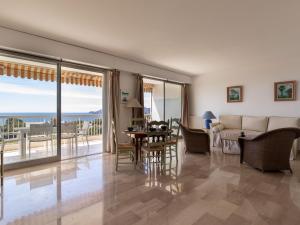 a living room with a couch and a table and chairs at Apartment Les Horizons by Interhome in Cannes