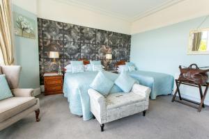 sypialnia z łóżkiem, krzesłem i kanapą w obiekcie Shelleven Guest House w mieście Bangor
