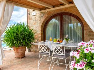 a table and chairs on a patio with flowers at Holiday Home La Vecchia Pieve by Interhome in Castelfiorentino