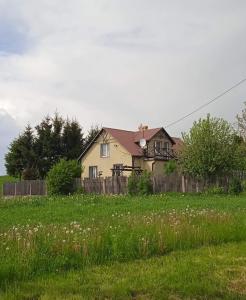a house behind a fence in a field at U Ingi in Szypliszki