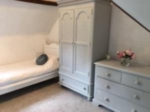 a white bedroom with a bed and a dresser at Beautiful 1 bed cottage in countryside in Tring