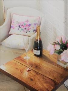 - une bouteille de vin et un verre sur une table en bois dans l'établissement Beautiful 1 bed cottage in countryside, à Tring
