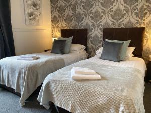 2 camas con toallas en una habitación en The Crown Hotel en Newton Stewart