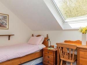 a bedroom with a bed and a desk and a skylight at Holiday Home Ducks Dive by Interhome in Saint Keyne