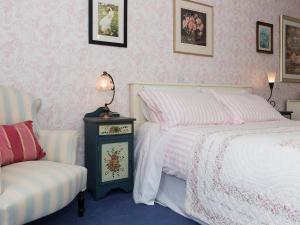 a bedroom with two beds and a chair at Holiday Home Ducks Dive by Interhome in Saint Keyne