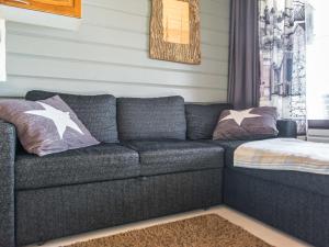a couch in a living room with pillows on it at Holiday Home Mustalampi 5 satakieli by Interhome in Ruka