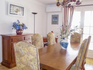 a dining room table with chairs and a vase of flowers at Apartment Princesse by Interhome in Les Issambres