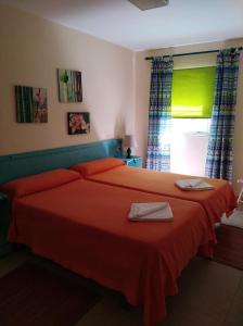 - une chambre avec un lit doté de draps rouges et une fenêtre dans l'établissement Finca Borbolan y La Roseta, à Valle Gran Rey