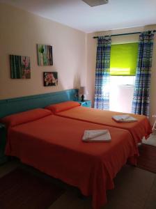 a bedroom with a bed with red sheets and a window at Finca Borbolan y La Roseta in Valle Gran Rey