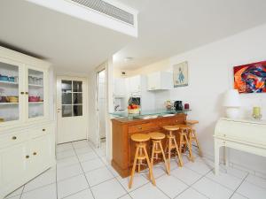 カンヌにあるApartment Cannes Bay-2 by Interhomeの白いキャビネットとバースツール付きのキッチン