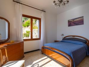ein Schlafzimmer mit einem Bett, einer Kommode und einem Fenster in der Unterkunft Apartment Canarda by Interhome in Ventimiglia