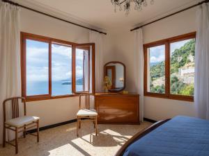 Schlafzimmer mit einem Bett, einem Spiegel und Fenstern in der Unterkunft Apartment Canarda by Interhome in Ventimiglia