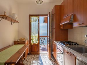 ヴェンティミリアにあるApartment Canarda by Interhomeのバルコニーに面したドア付きのキッチン