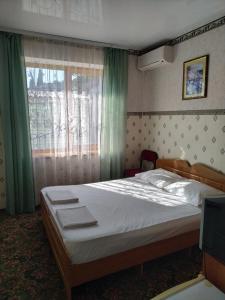 1 dormitorio con 1 cama grande y ventana en Самарский дом, en Lazarevskoye