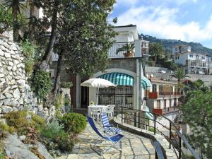 文蒂米利亞的住宿－Apartment Gli Smeraldi by Interhome，阳台上摆放着几把椅子和一把遮阳伞