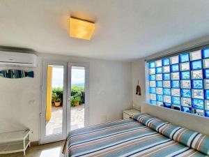 a bedroom with a bed and a large window at La Perla del Golfo in Capoliveri