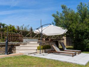 un patio con una sombrilla blanca y 2 sillas en Holiday Home Il Casaletto by Interhome, en Vetralla