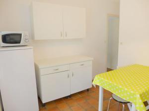 サン・マロにあるHoliday Home Pasteur by Interhomeのキッチン(白いキャビネット、電子レンジ付きテーブル付)