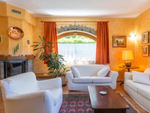 Una sala de estar con dos sofás blancos y una chimenea. en Apartment Fulvia - CCO125 by Interhome, en Colico