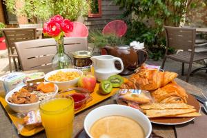 una mesa con una bandeja de comida para el desayuno. en Le Magnan, en Aviñón