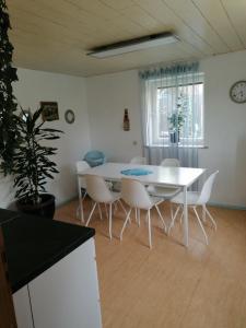 Thomas Haus في غنزبرغ: غرفة طعام مع طاولة بيضاء وكراسي بيضاء