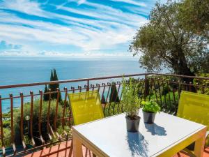 d'une table et de chaises sur un balcon avec vue sur l'océan. dans l'établissement Apartment Paradise View by Interhome, à Mortola Inferiore