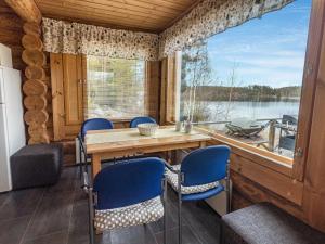 uma cozinha com mesa e cadeiras e uma grande janela em Holiday Home Aurinkotupa by Interhome em Kokkosenlahti
