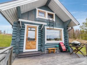 a tiny house on a deck with a grill at Holiday Home Aurinkotupa by Interhome in Kokkosenlahti