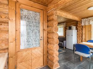 uma porta de madeira num quarto com uma mesa e um frigorífico em Holiday Home Aurinkotupa by Interhome em Kokkosenlahti