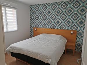 a bedroom with a bed and a blue wall at Appartement La pinède - Tout Confort - Piscine de saison - 2 chambres - Proche plage et Commerces in Le Barcarès