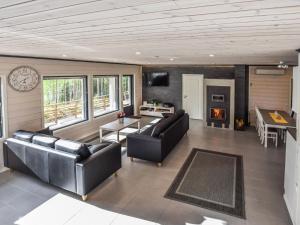 ein Wohnzimmer mit 2 Ledersofas und einem Tisch in der Unterkunft Holiday Home Hämyrinne by Interhome in Kokkosenlahti