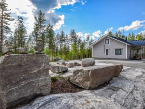 a garden with large rocks in front of a house at Holiday Home Hämyrinne by Interhome in Kokkosenlahti