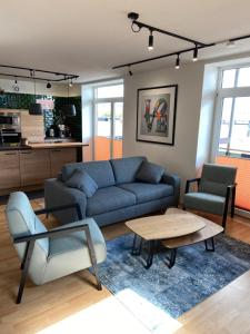 a living room with a blue couch and a table at Atelier Achtung Ausblick! in Rendsburg