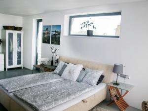a bedroom with a large bed with a window at Holiday Home Řeporyje by Interhome in Prague