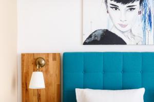 メルビッシュ・アム・ゼーにあるPension Laubenhofの青いヘッドボード付きのベッド上の絵画