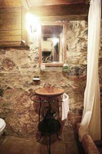 kamienna łazienka z umywalką i lustrem w obiekcie Comfortable house with sea view in Anatoli + jacuzzi w mieście Anatolí +25 zdjęć