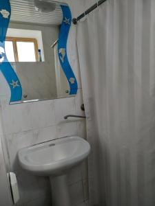 y baño con lavabo y espejo. en Самарский дом, en Lazarevskoye