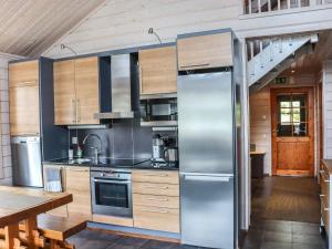 a kitchen with a stainless steel refrigerator at Holiday Home Aurinko-saaga 5 paritalo by Interhome in Hyrynsalmi